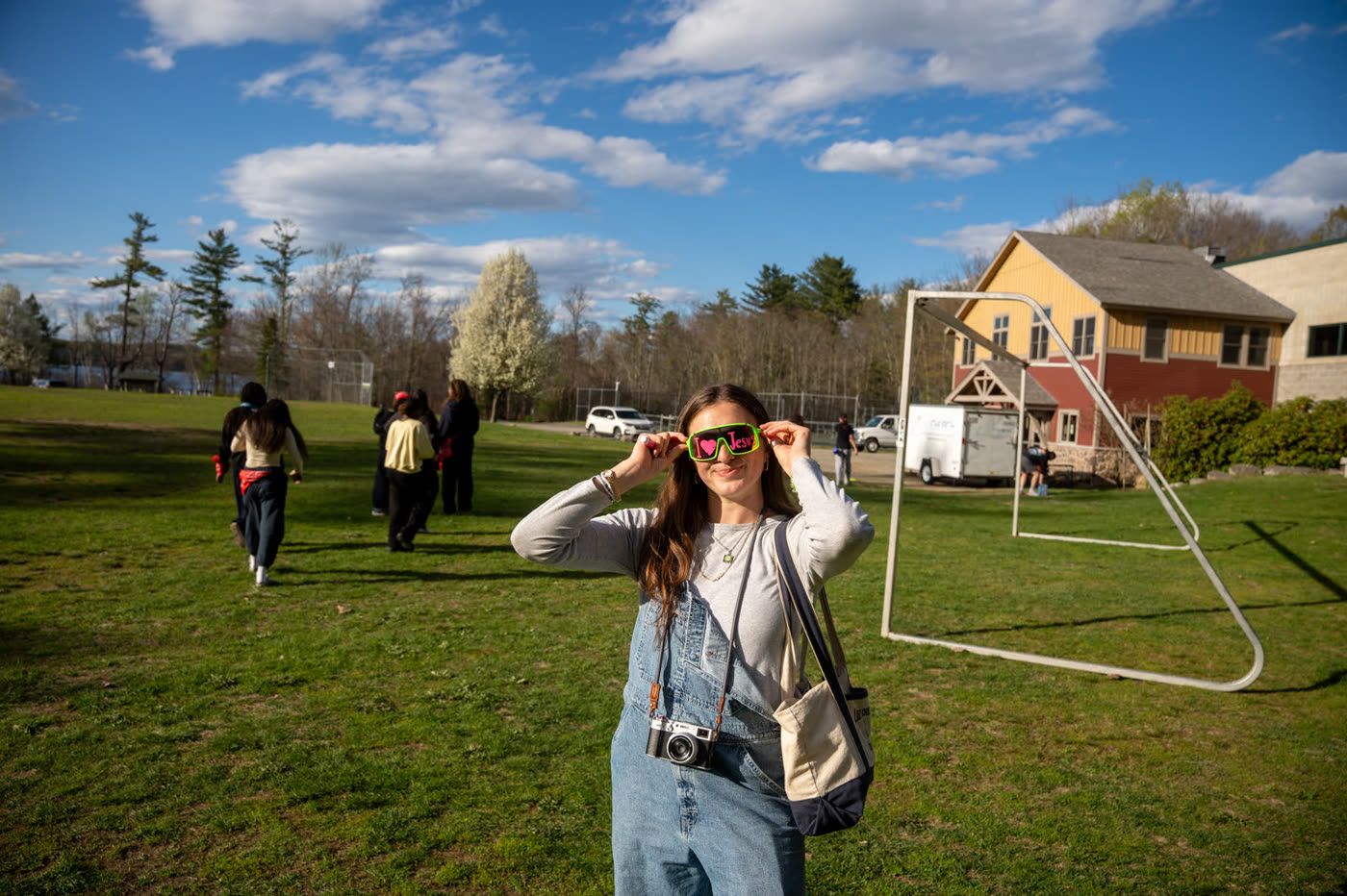 Student showing off I love Jesus sunglasses on the field