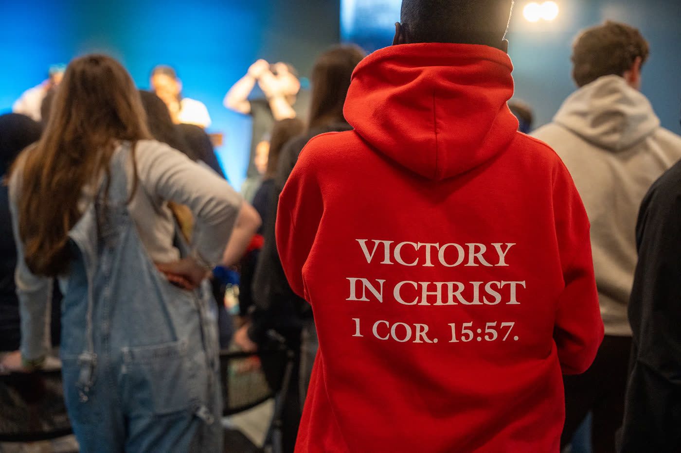 Student in a Victory in Christ hoodie during worship
